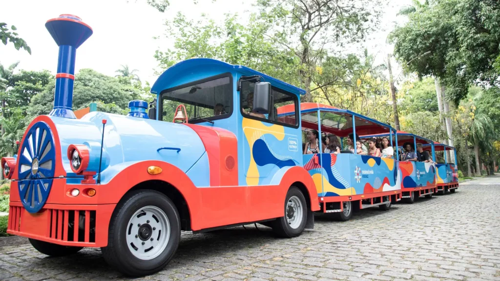 Deltrain Delga EV electric tourist train locomotive operating in a park environment