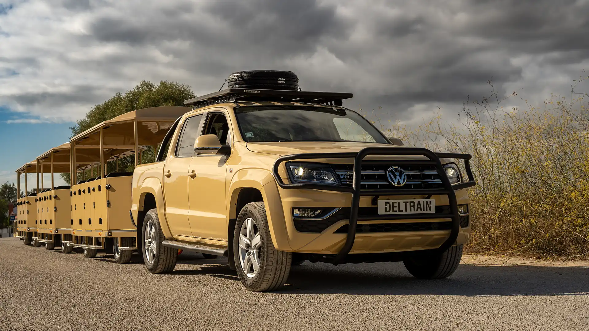 Deltrain Safari ICE pickup-based tourist road train towing passenger wagons on rugged terrain