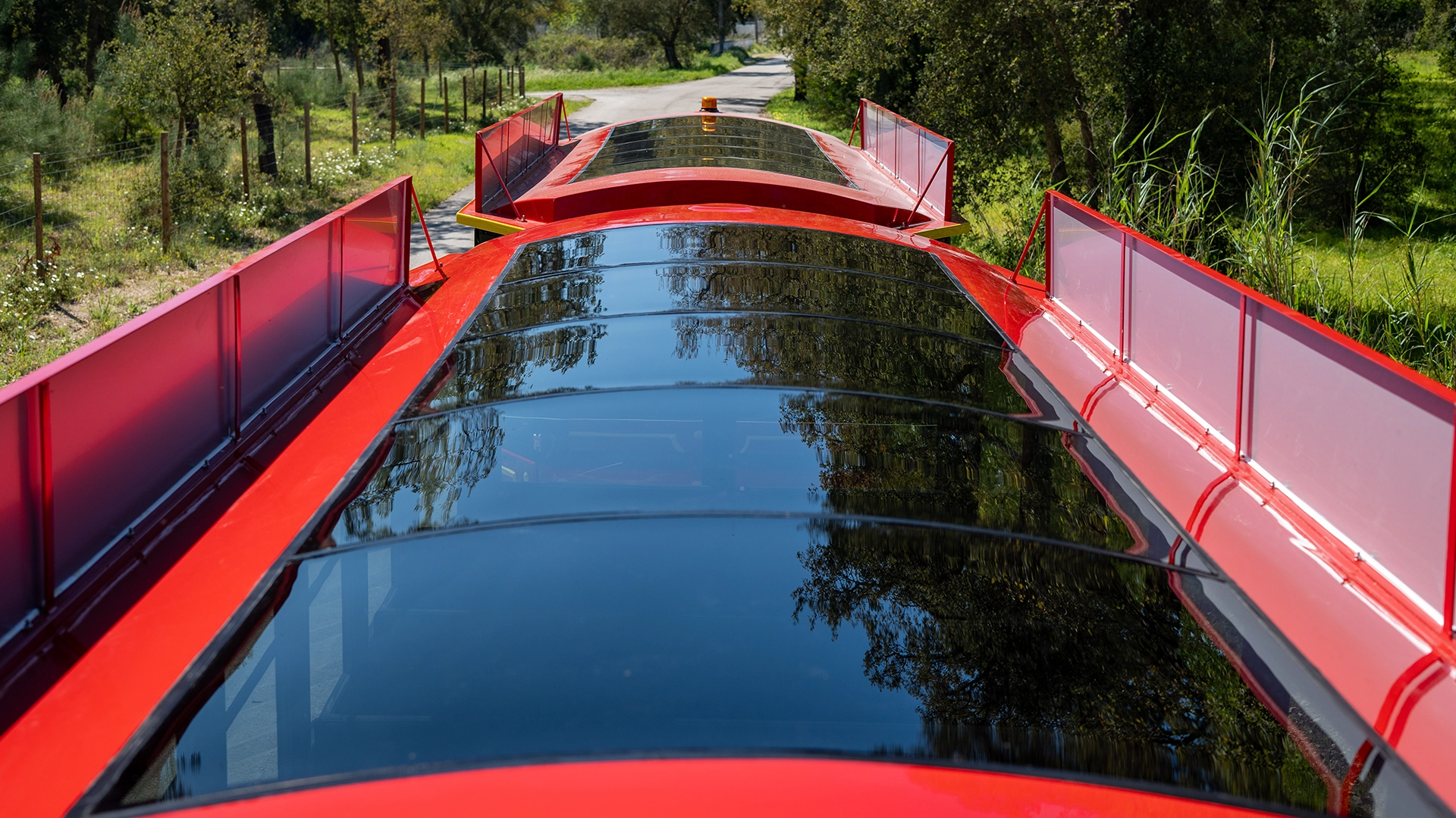 Glossy red roof and side rails of a Deltrain Prime enclosed tourist train wagon seen from above
