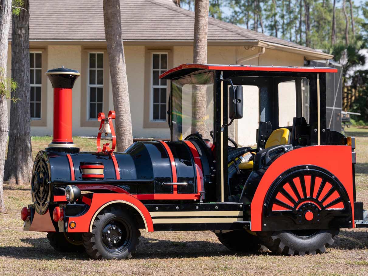 Red and black TDJ50 locomotive, side view, in front of a building